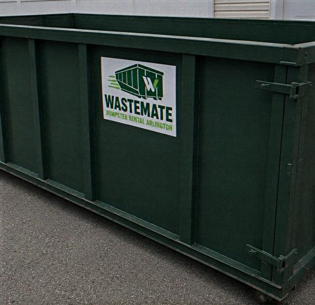 Open-top dumpster standing at a commercial building